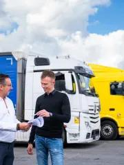 Two people standing near the trucks